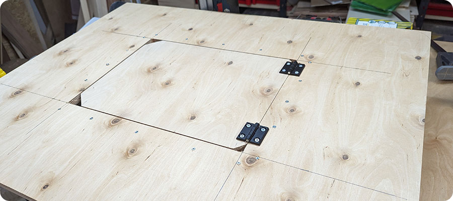 Die Klappe mit Winkelscharnieren an der Tischplatte befestigen